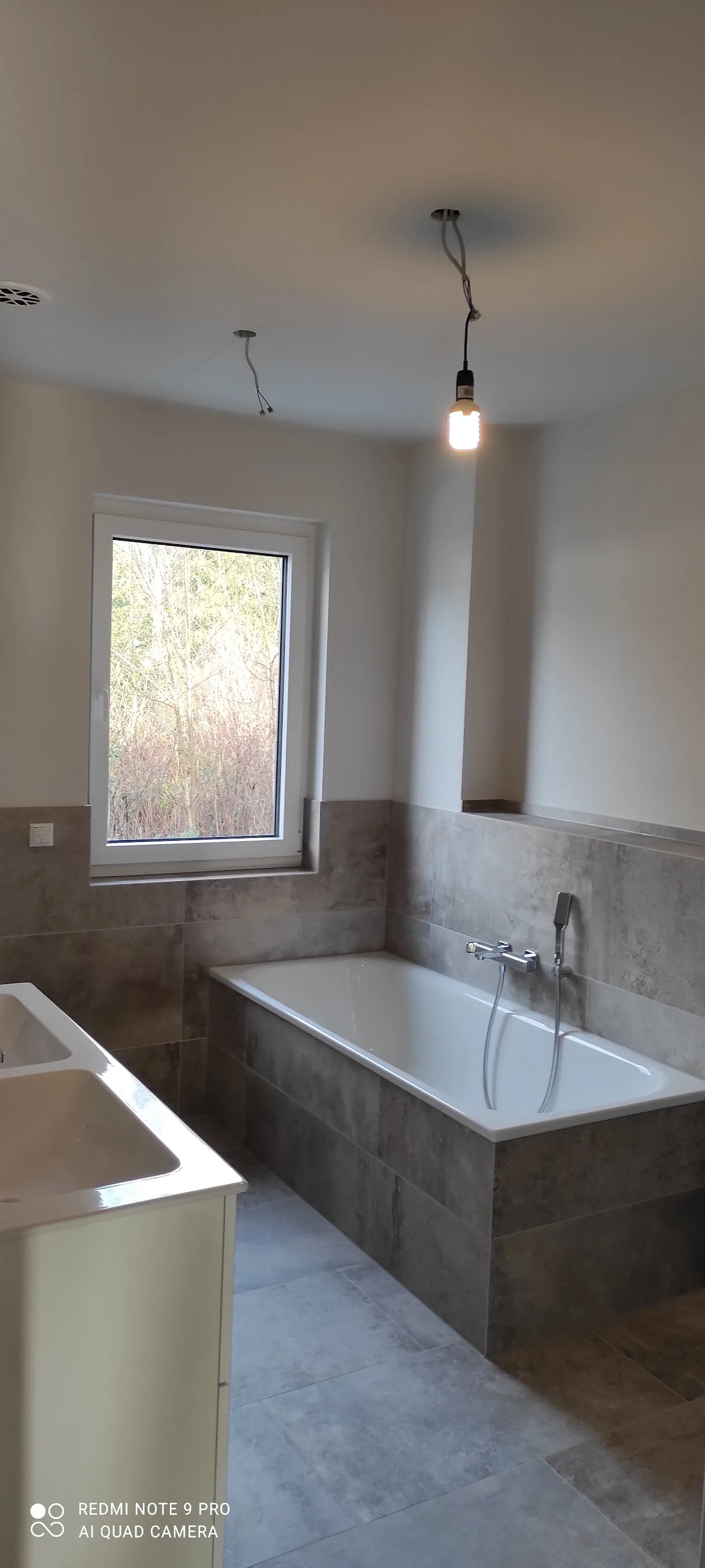 Modernes Badezimmer mit Betonoptik und Fenster