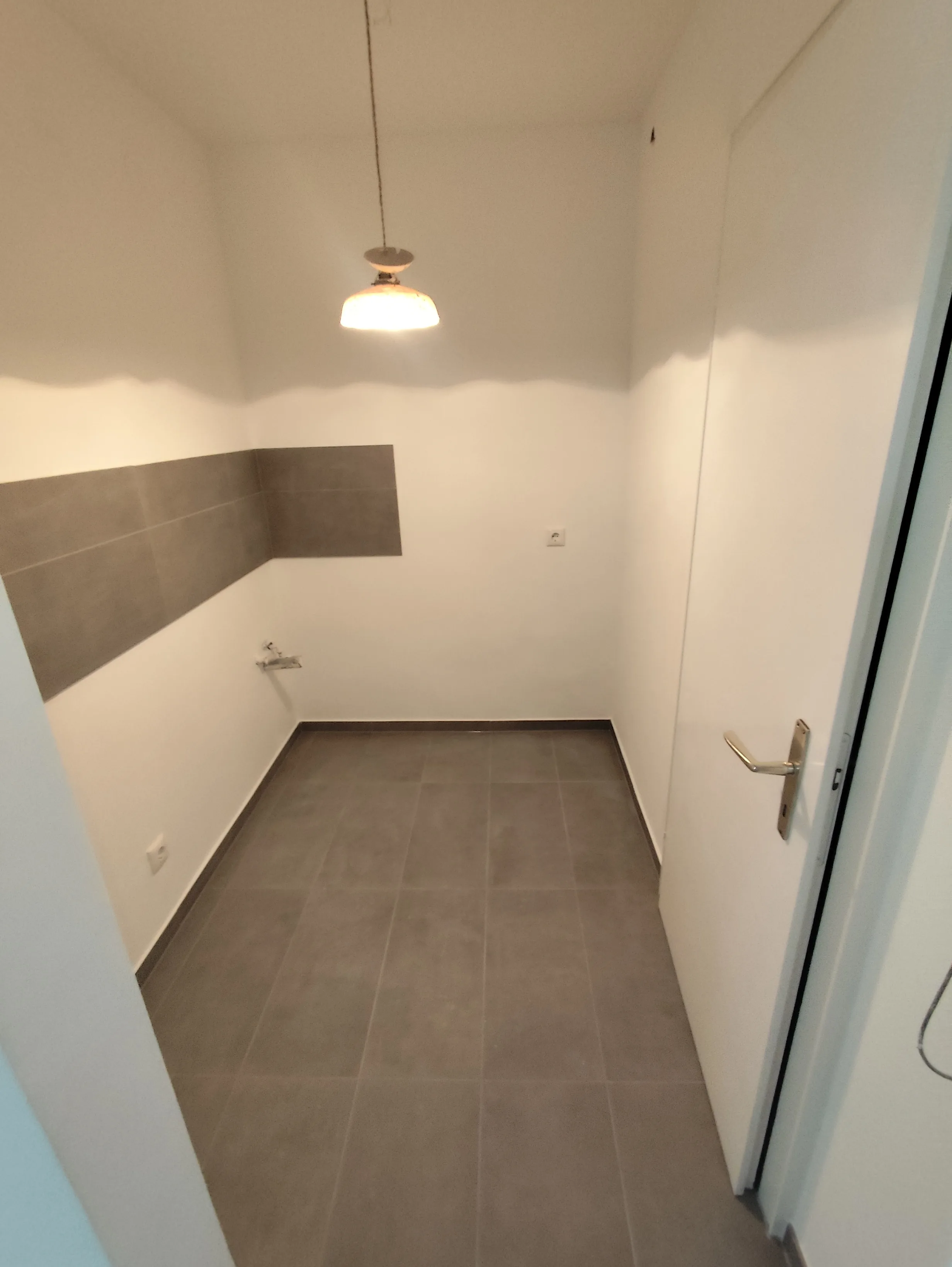 Renovierte Wand mit Fliesen und neuem Bodenbelag im Innenraum