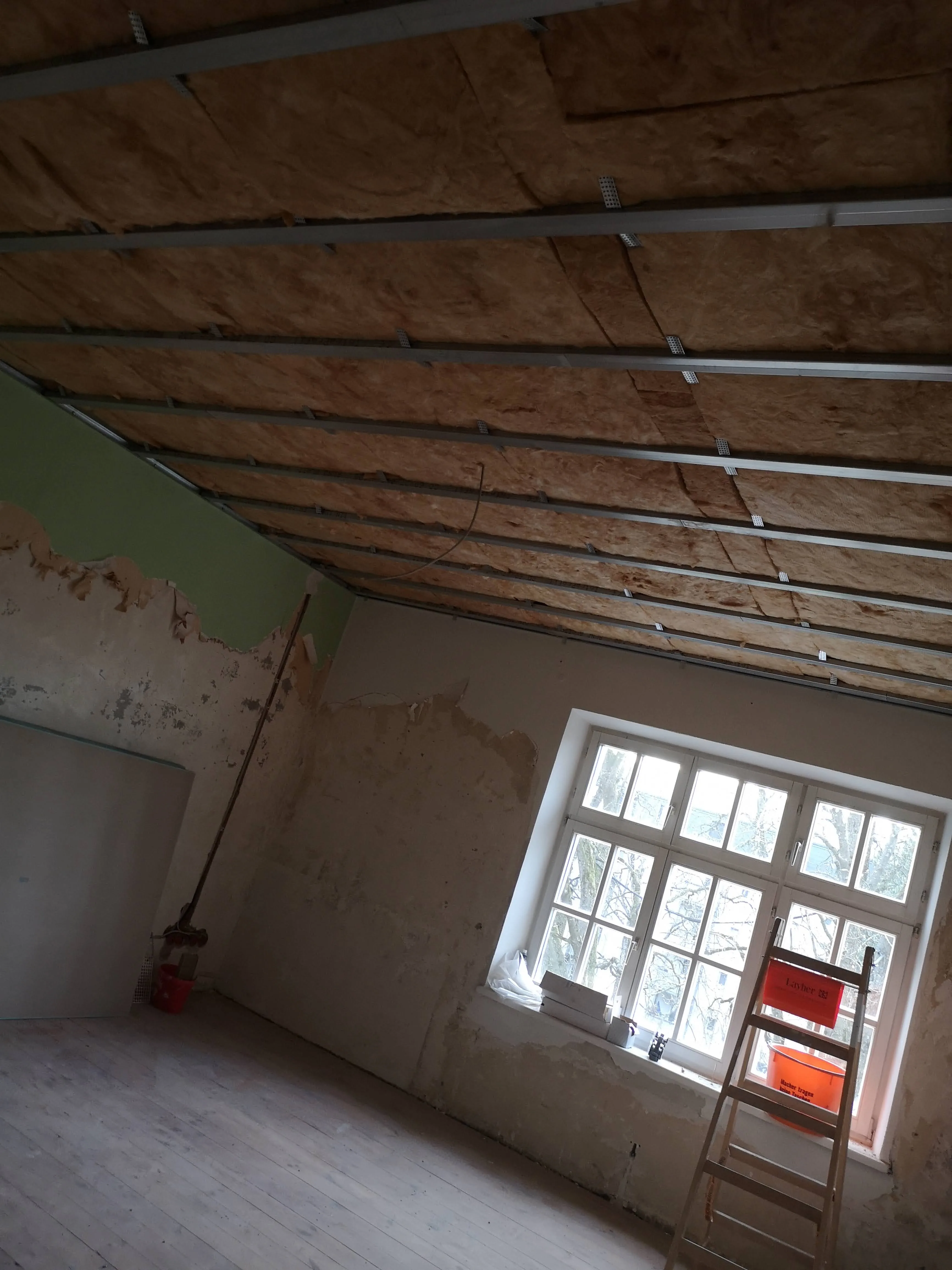 Trockenbauarbeiten mit abgehängter Decke in einer renovierungsbedürftigen Wohnung