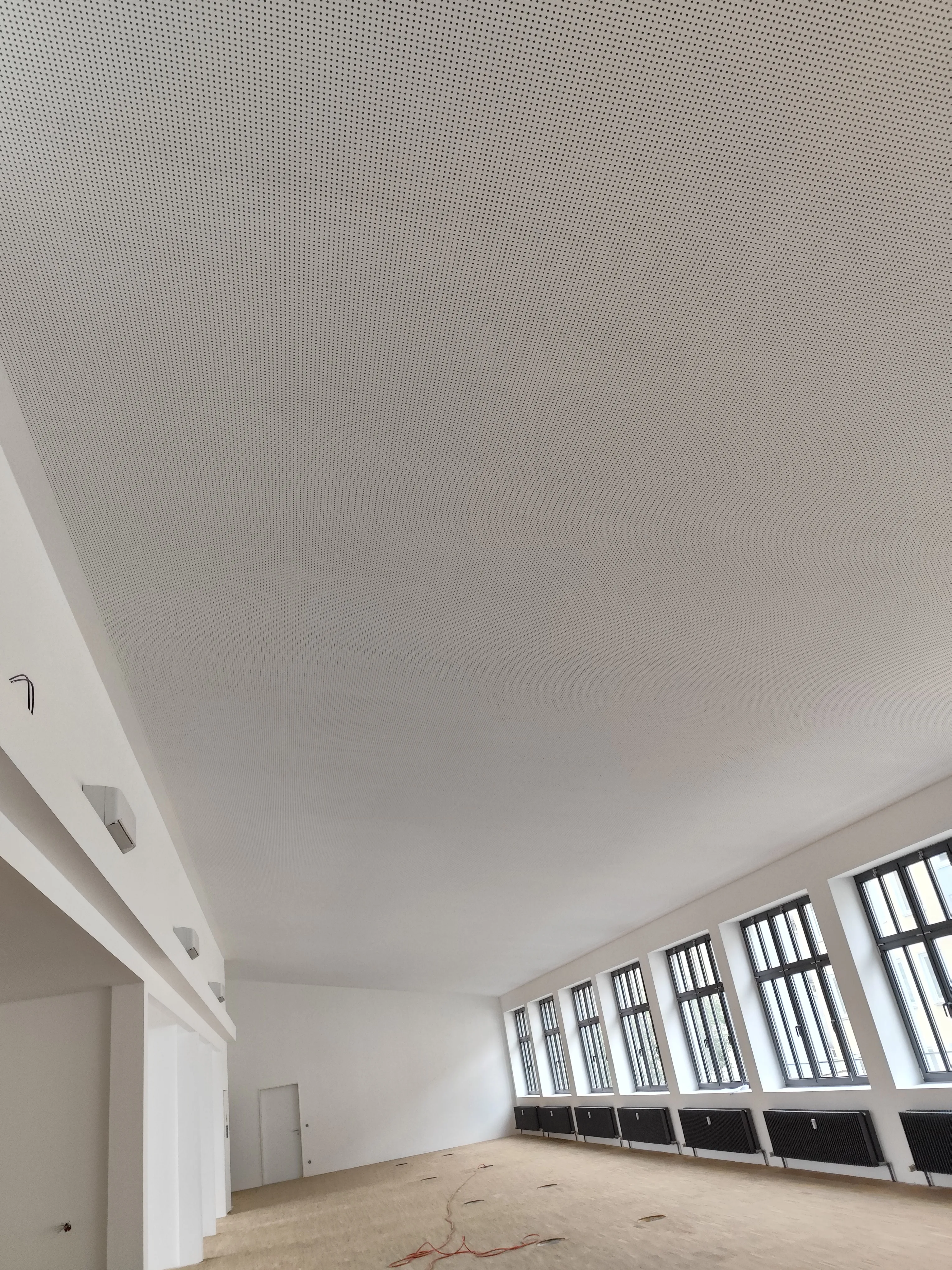 Blick auf eine abgehängte Decke in einem modernisierten Raum mit großen Fenstern