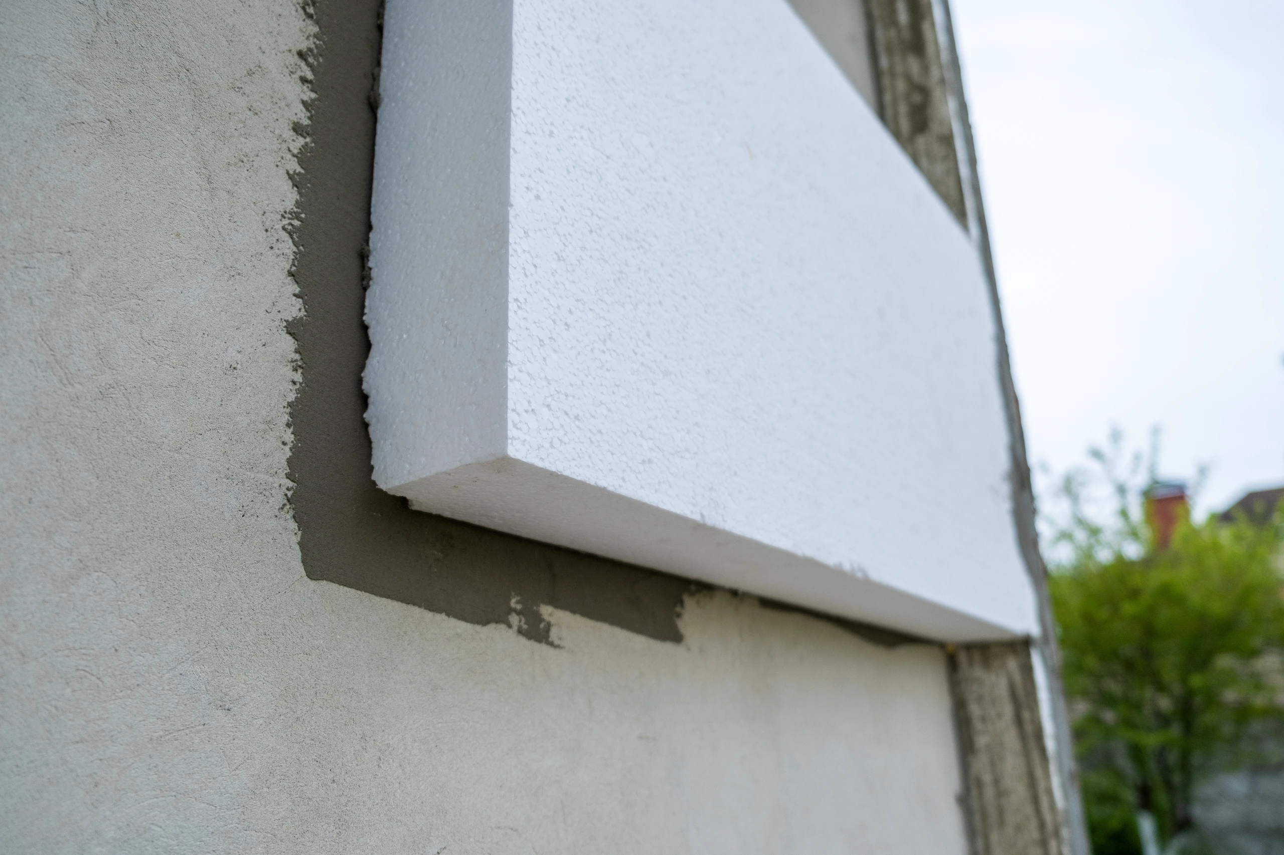 Detailansicht von Dämmplatten, die an eine Wand montiert werden, im Rahmen der Fassadendämmung