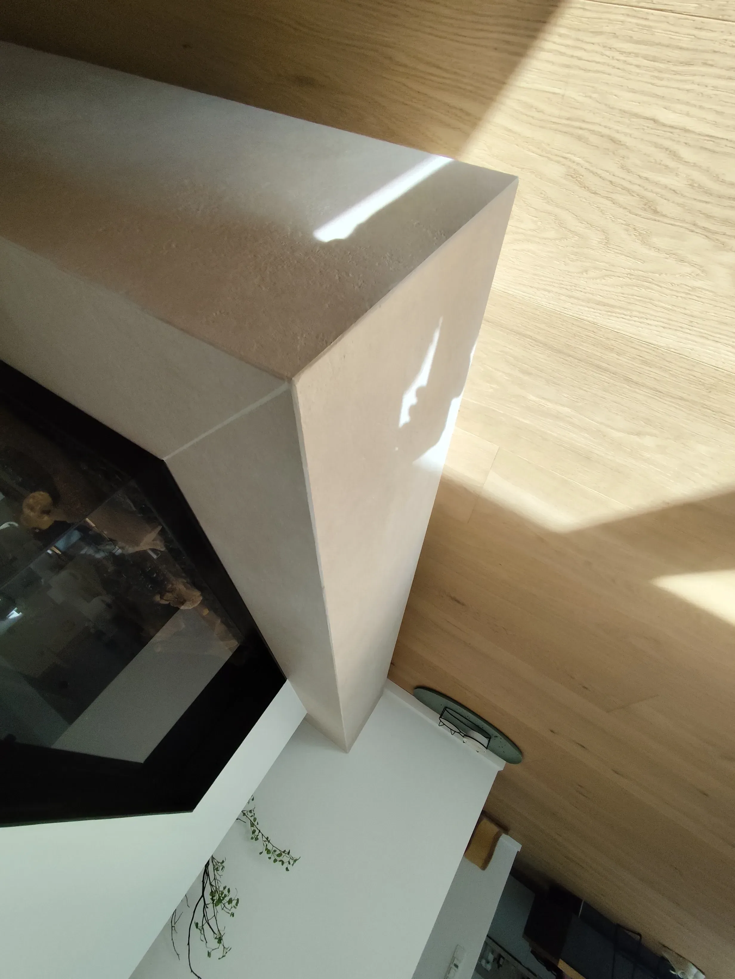 Detailaufnahme eines modern gestalteten Raumes mit einer geschwungenen Wand und Boden aus Holz