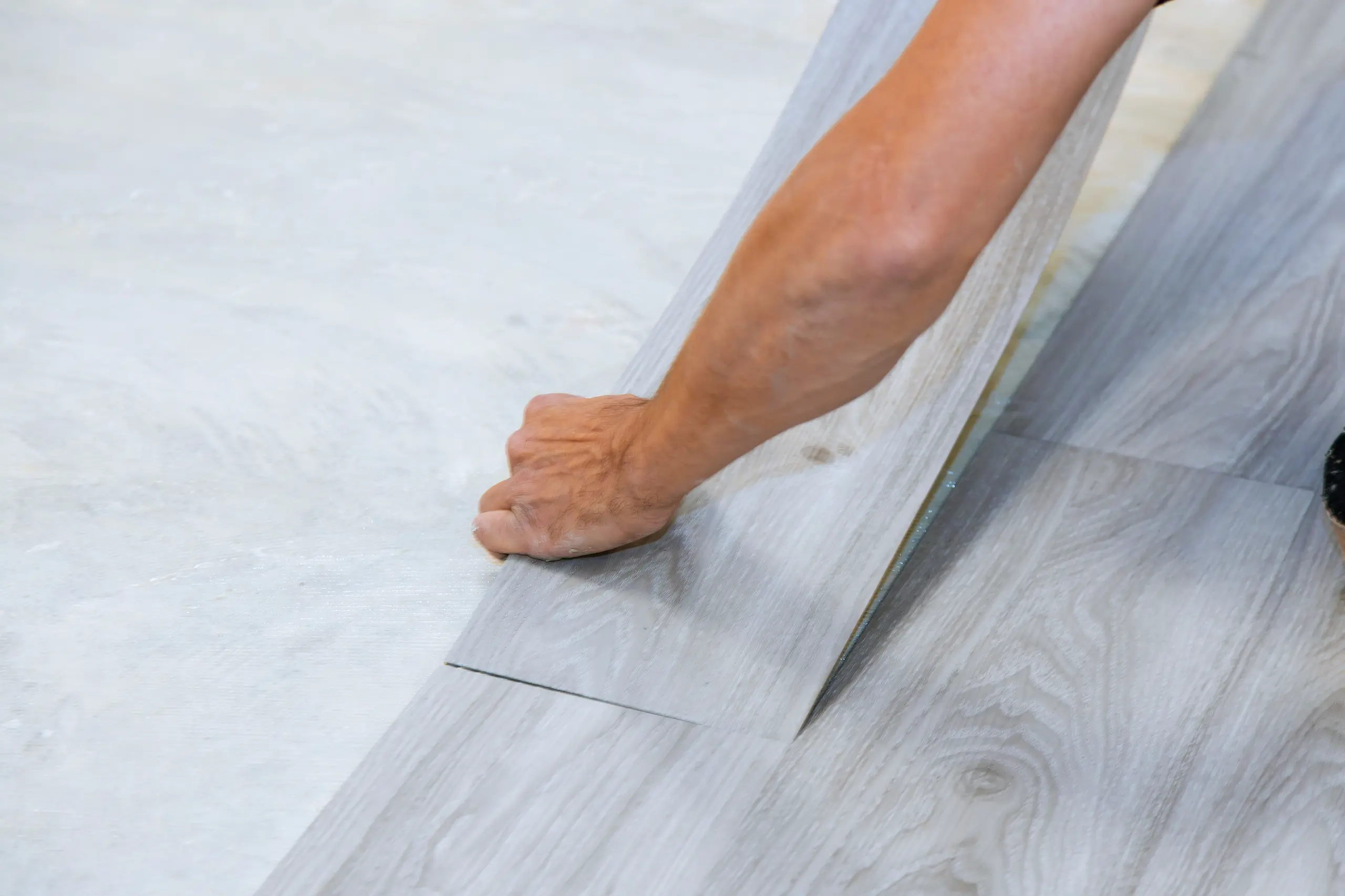 Verlegung von Vinylboden durch Handwerker in einem Wohnraum